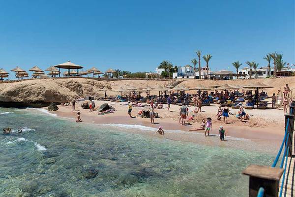 Strandszene am Amphoras Beach Hotel in Sharm el Sheikh mit vielen Gästen und Sonnenschirmen
