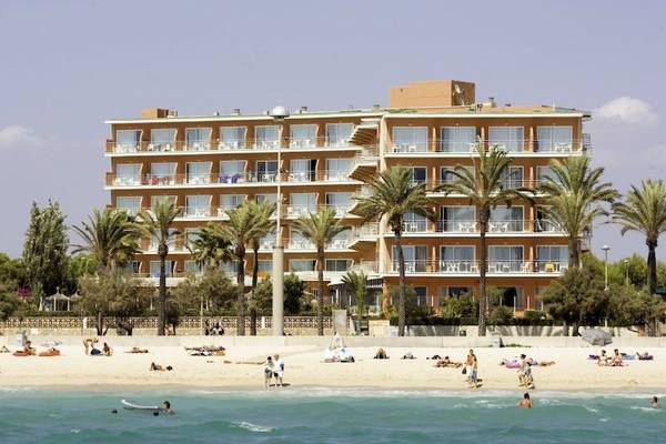 HSM Golden Playa Hotel am Strand mit vielen Gästen, Palmen und Sonnenschirmen.