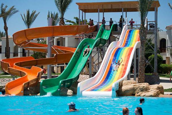 Wasserrutschen im Freien im Amphoras Beach Hotel mit mehreren Rutschen und Personen, die Spaß haben.