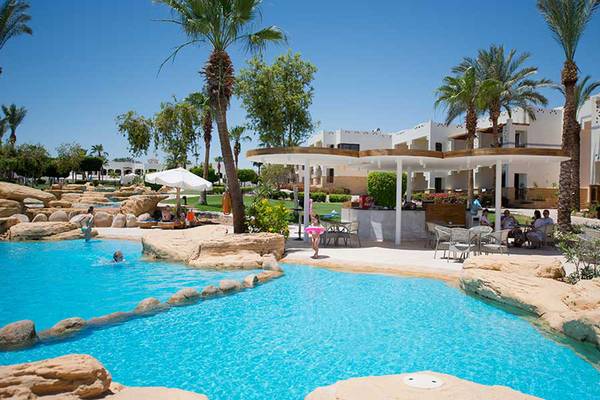 Außenpoolbereich des Amphoras Beach Hotels mit Palmen und Felsstrukturen.