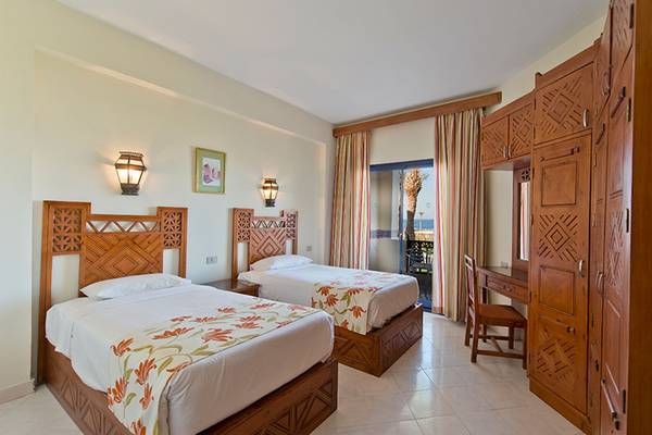 Doppelzimmer im Amphoras Beach Hotel mit zwei Betten, Holzmöbeln und Meerblick.