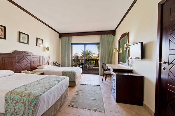 Doppelzimmer im Amphoras Beach Hotel mit zwei Betten, Balkon, Fernseher und Schreibtisch.
