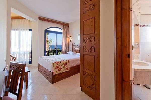 Innenansicht eines Zimmers im Amphoras Beach Hotel mit Bett, Balkon und Meerblick.