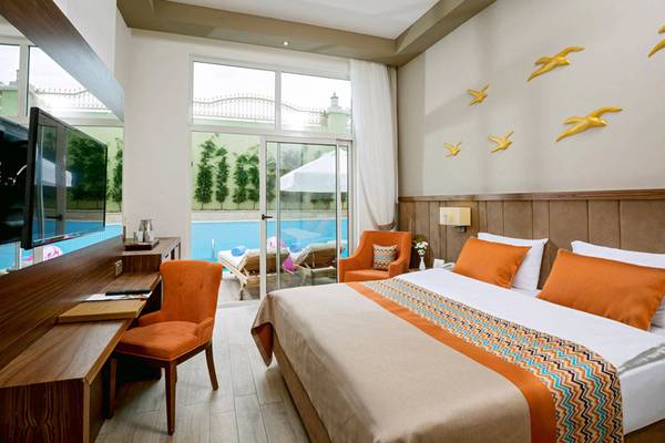 Ein modernes Schlafzimmer im Side Royal Palace Hotel & Spa mit Blick auf den Pool.