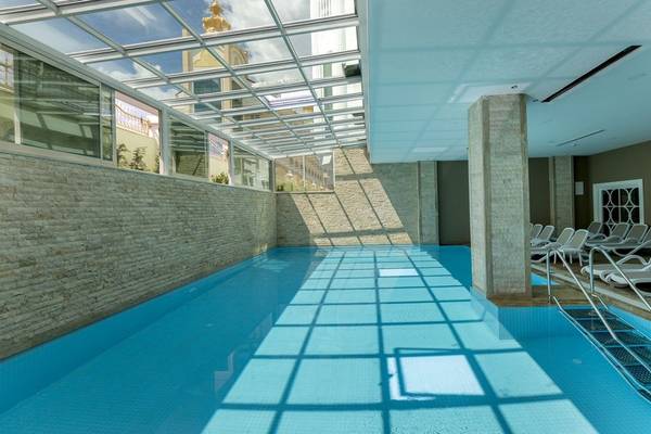 Innenpool des Side Royal Palace Hotel & Spa mit Glasdach und Sonnenlicht.