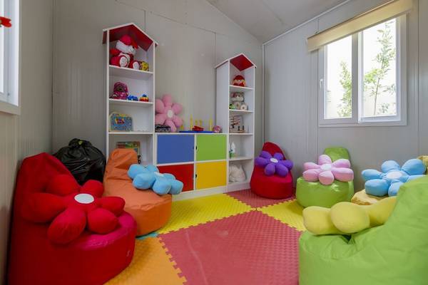 Kinderzimmer im Side Royal Palace Hotel & Spa mit bunten Kissen und Spielzeugregalen.