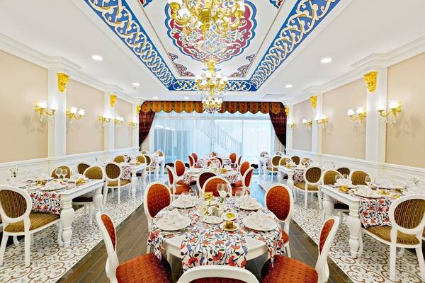 Innenbereich des Side Royal Palace Hotel & Spa mit dekorierten Tischen und Stühlen.