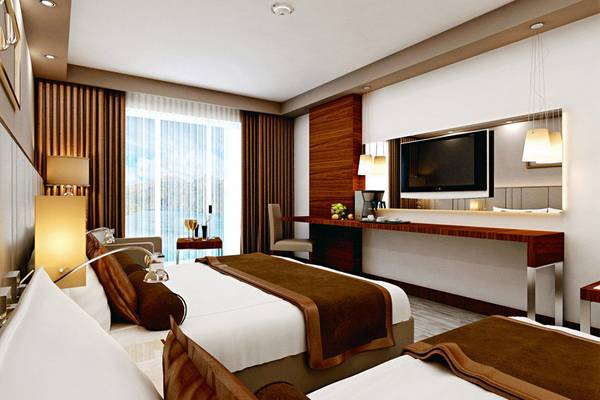 Schlafzimmer des Side Royal Palace Hotels mit zwei Betten, Fernseher und Schreibtisch