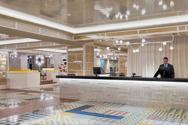 Empfangsbereich des H10 Las Palmeras Hotels mit geometrischem Bodenmuster und modernen Möbeln.