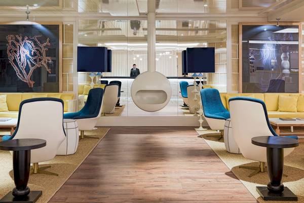 Lobby des H10 Las Palmeras Hotels mit moderner Einrichtung, Spiegeln und Kunstwerken.