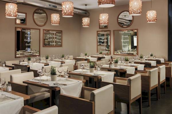 Foto des Innenbereichs des Restaurants im H10 Las Palmeras Hotel mit elegant eingerichteten Tischen und Stühlen.
