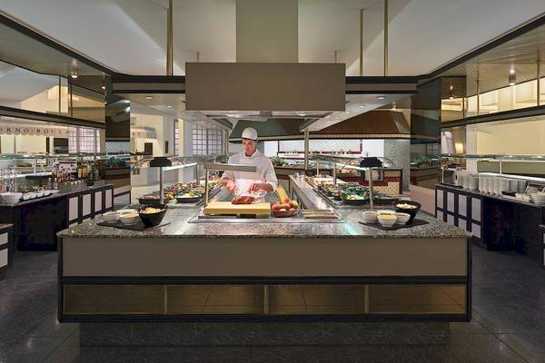 Im Restaurant H10 Las Palmeras bereitet ein Koch ein Buffet zu.