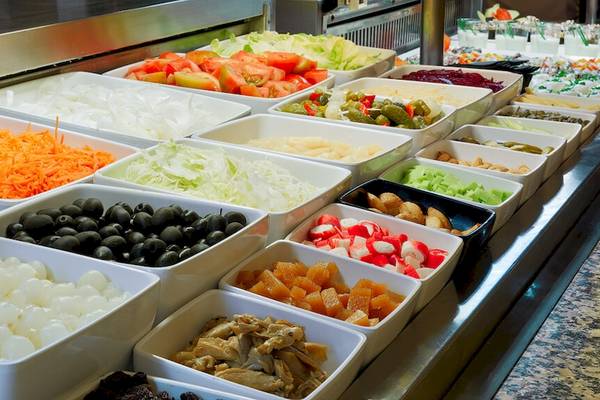 Buffet mit verschiedenen Gemüse- und Obstsorten, darunter Tomaten, Gurken, Oliven, Datteln und mehr.