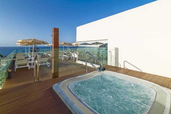 Hotelterrasse des H10 Las Palmeras mit Whirlpool und Meerblick, umgeben von Sonnenliegen und Schirmen