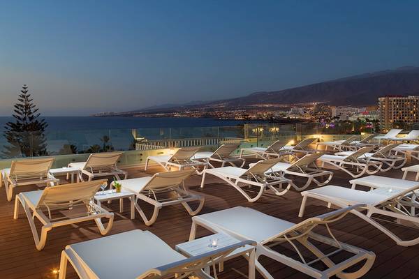 Terrasse des H10 Las Palmeras Hotels mit Blick auf die Stadt und den Ozean bei Nacht