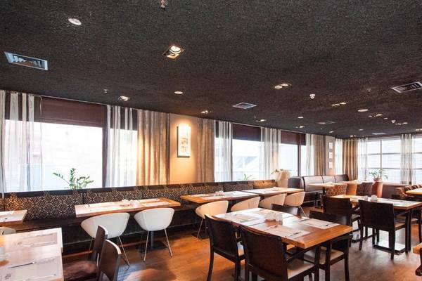 Innenansicht des Restaurants des XO Hotels Blue Tower mit Tischen und Stühlen.