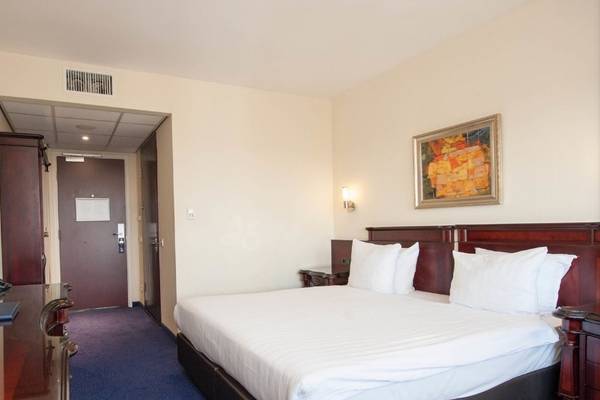 Hotelzimmer im XO Hotels Blue Tower mit Bett, Fernseher und Schreibtisch.