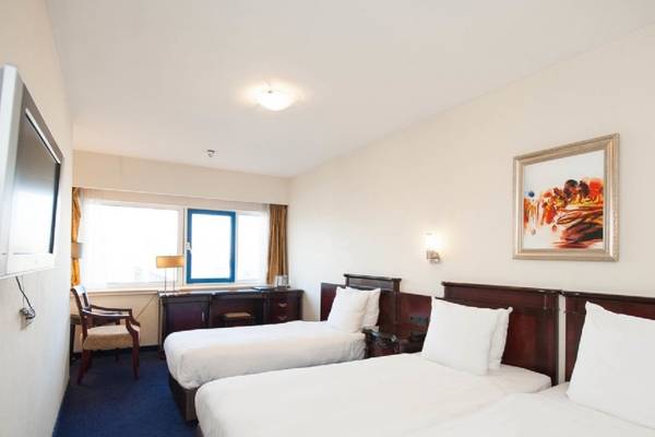 Doppelzimmer im XO Hotels Blue Tower mit zwei Betten, Fernseher und Schreibtisch.