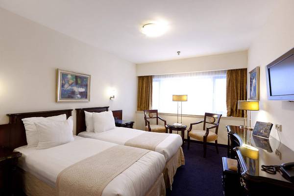 Doppelzimmer im XO Hotels Blue Tower mit zwei Betten, Sesseln, Schreibtisch und Fernseher.