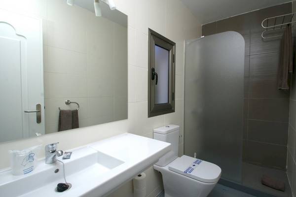 Badezimmer im Turbo Club mit Spiegel, Waschbecken, Toilette und Duschkabine.