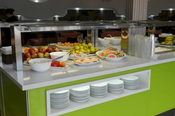 Buffet-Tisch im Turbo Club Hotel mit verschiedenen Obstsalaten, Desserts und Getränken.