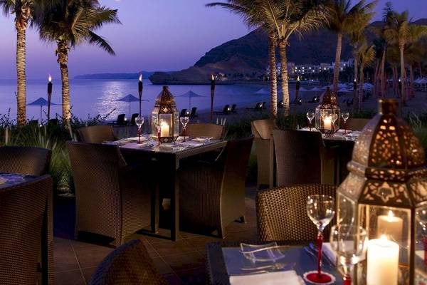 Abendessen auf der Terrasse des Shangri-La Barr Al Jissah Resorts bei Nacht mit Blick auf das Meer und die Berge.