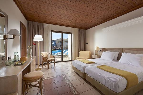 Hotelzimmer im Mitsis Royal Mare Thalasso & Spa Resort mit zwei Betten, Poolsicht und modernem Interieur.