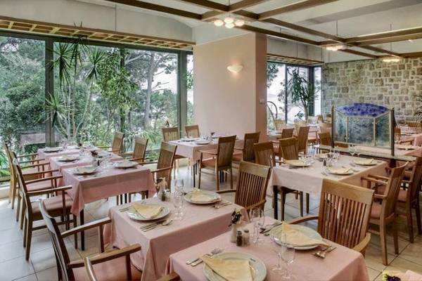 Innenansicht des Restaurants im BlueSun Hotel Berulia mit gedeckten Tischen und Stühlen.