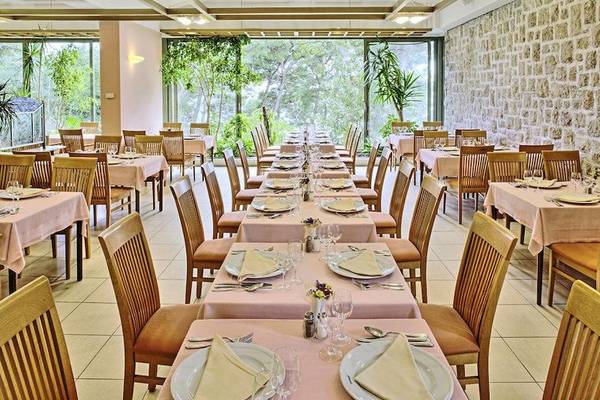 Innenansicht des Restaurants im BlueSun Hotel Berulia mit gedeckten Tischen und Stühlen.