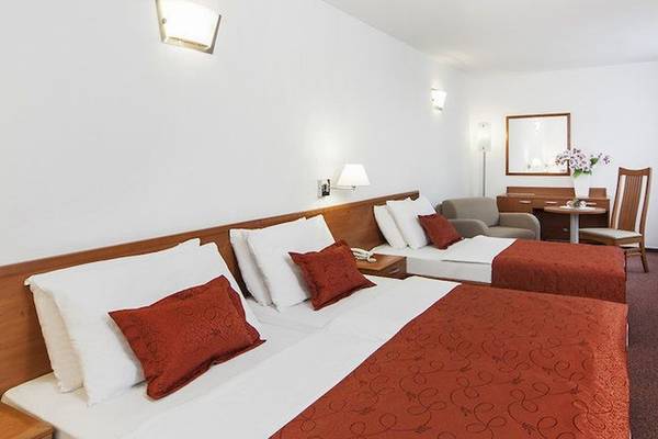 Doppelzimmer im BlueSun Hotel Berulia mit zwei Betten, Fernseher und einem Schreibtisch.