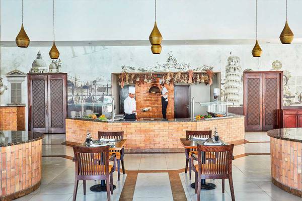Das Innere eines Restaurants im Steigenberger Aqua Magic Hotel mit offenem Backofen und italienisch inspirierter Wandgestaltung.