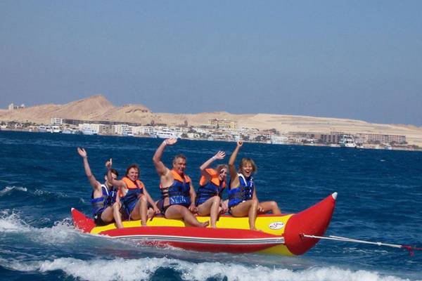 Gruppe auf rotem und gelbem Schlauchboot mit Stegenberger Aqua Magic im Hintergrund.