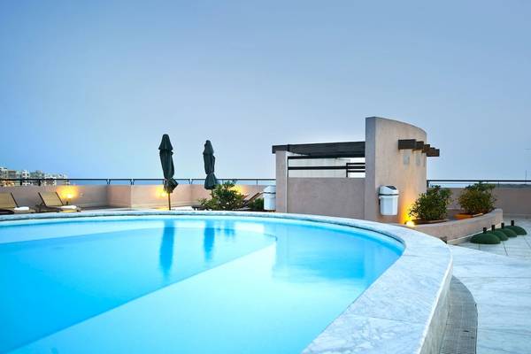 Dachpool des Calypso Hotels mit Sonnenliegen und Pflanzen