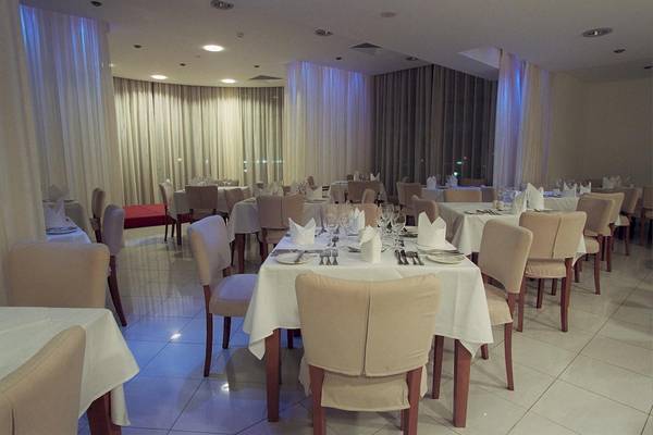 Innenansicht des Restaurants im Calypso Hotel mit gedeckten Tischen und Stühlen.