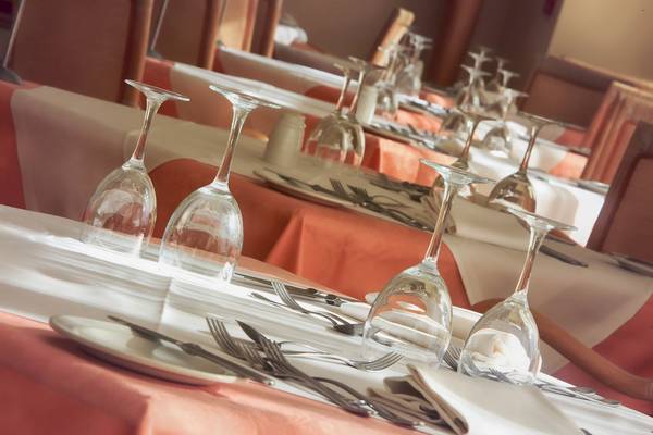 Ein Tisch im Calypso Hotel ist mit Gläsern, Besteck und Servietten gedeckt.