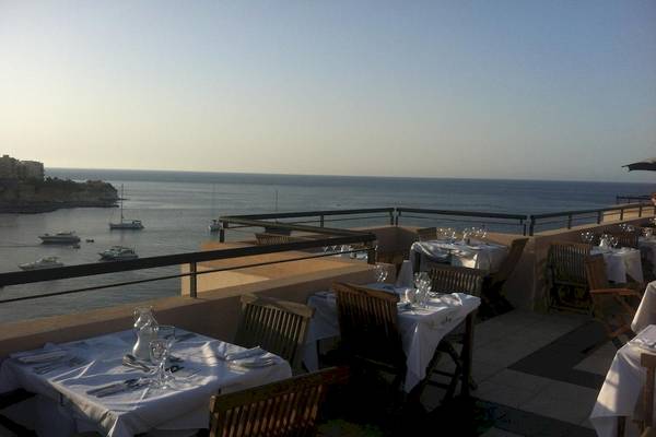 Terrasse des Calypso Hotels mit Blick auf das Meer und mehrere Boote