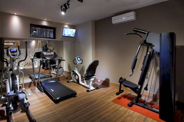 Fitnessstudio im Atlantis Beach Hotel auf Kreta mit diversen Geräten und Monitoren