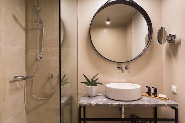 Badezimmer im Cretan Malia Park Hotel mit Dusche, Spiegel und Waschbecken.