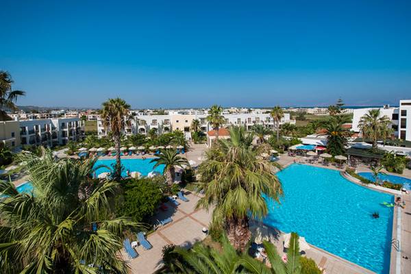 Hotelanlage mit Pool und Palmen von oben gesehen.