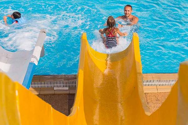 Familie im El Mouradi Skanes Hotel rutscht und schwimmt im Pool