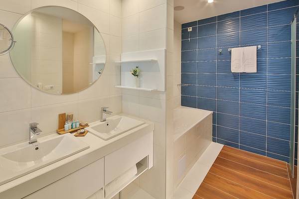Badezimmer im Maritim Hotel Paradise Blue Albena mit weißen Wänden und blauen Fliesen.