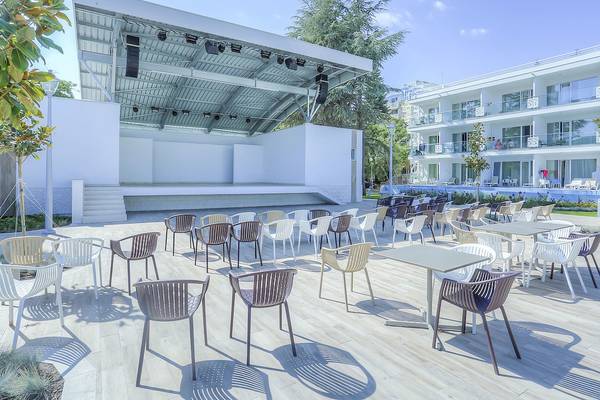 Außenbereich des Maritim Hotel Paradise Blue Albena mit Bühne, Stühlen und Tischen.