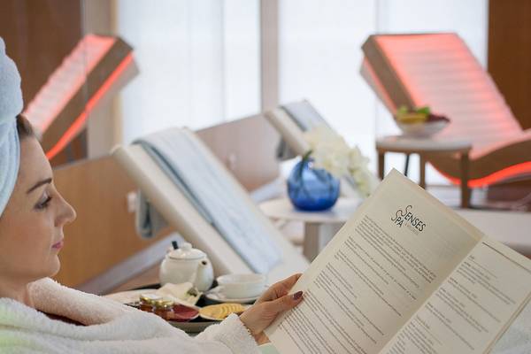 Frau im Bademantel liest das Behandlungsmenü im Spa des Maritim Hotel Paradise Blue Albena