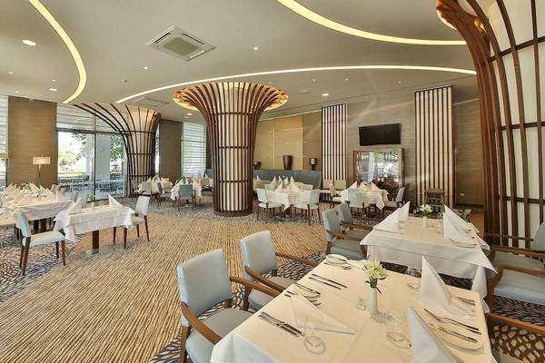 Innenbereich des Maritim Hotel Paradise Blue Albena, Restaurant mit gedeckten Tischen und Stühle.