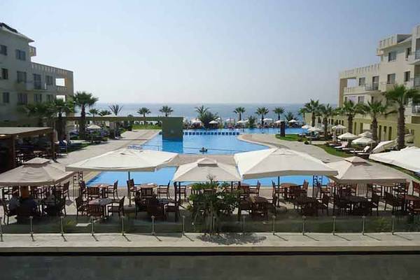 Außenbereich des Capital Coast Resort & Spa mit Swimmingpool und Sonnenschirmen