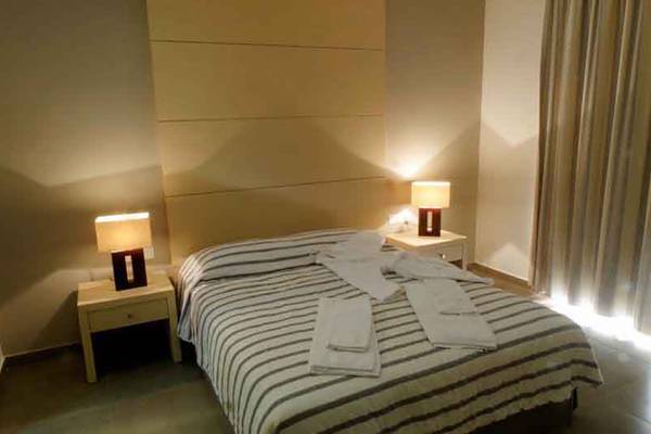 Schlafzimmer im Capital Coast Resort & Spa mit Bett, Nachttischen und Lampen.