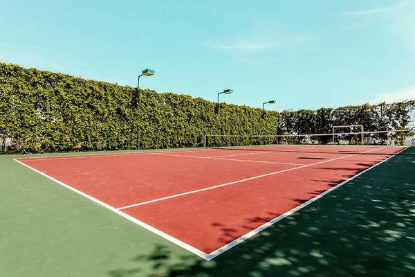 Tennisplatz im Turan Prince Hotel mit rotem Boden und weißen Linien.