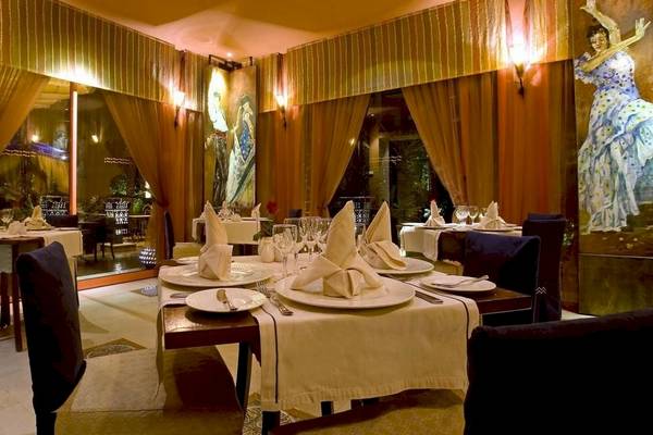 Das elegante Restaurant des Le Meridien N'Fis Hotel mit Tischdekorationen und Blick auf Außenlandschaft.