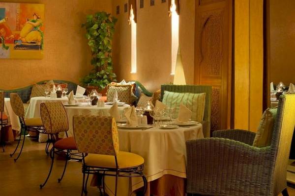 Innenansicht des Restaurants Le Meridien N'Fis mit gedeckten Tischen und Stühlen.