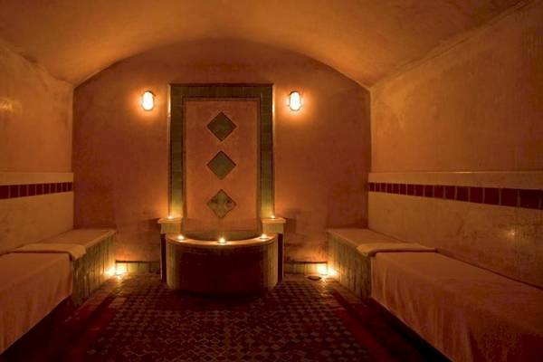 Innenansicht des Hammams im Le Meridien N'Fis Hotel mit zwei Ruhebetten und zentraler Badewanne.